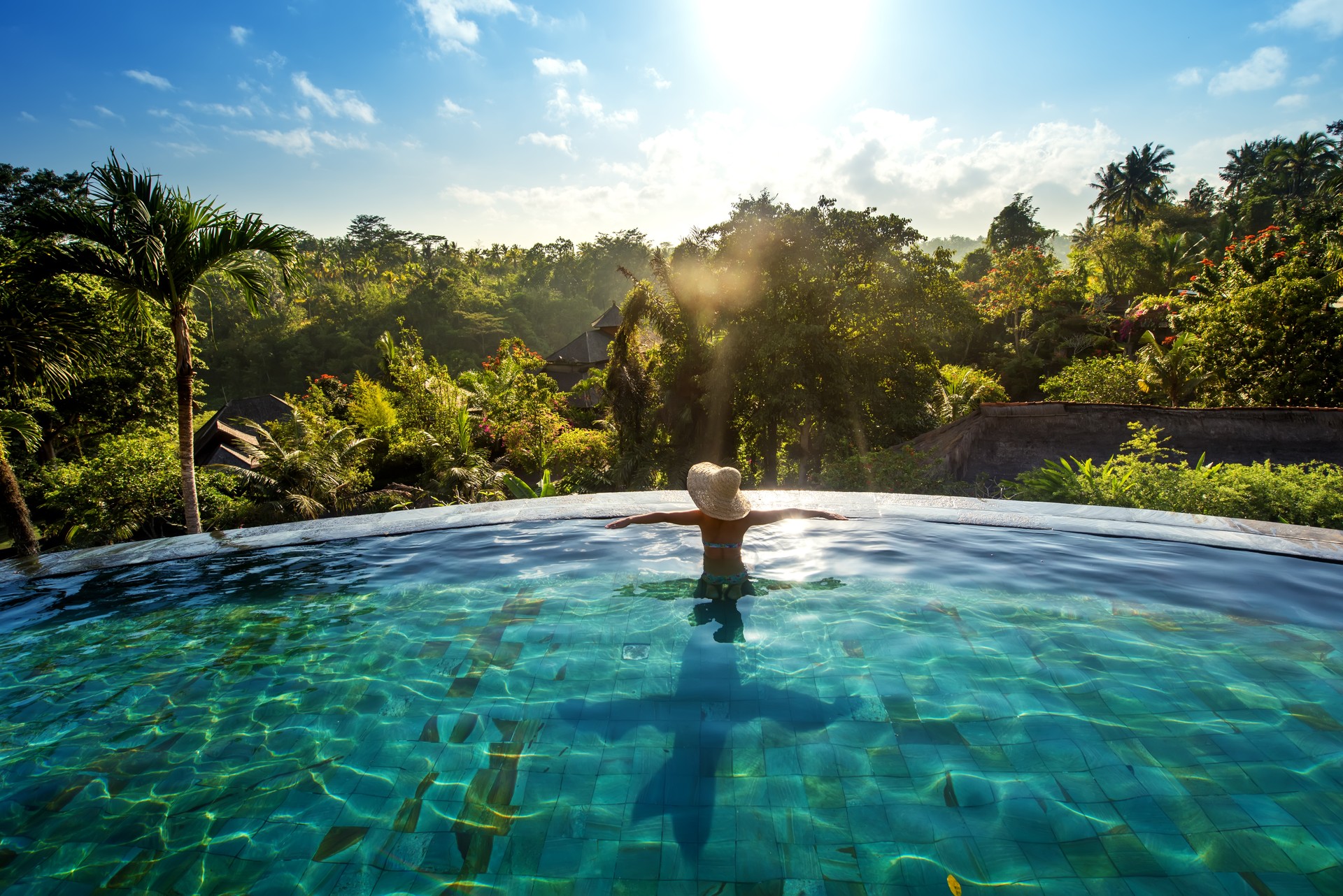 happiness concept. Woman sunbathing in infinity swimming pool at luxurious resort